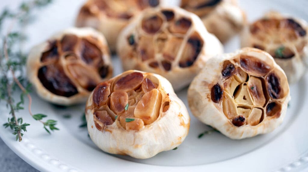 Roasted garlic on a white plate.