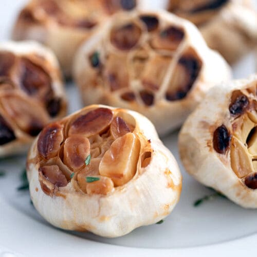 Roasted garlic on a white plate.