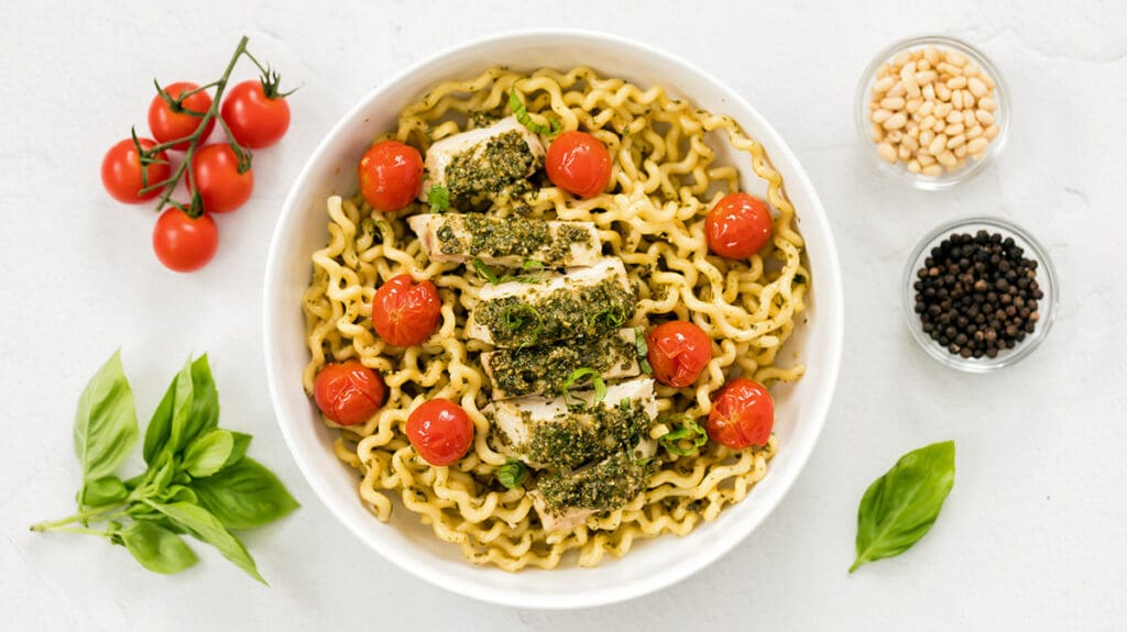 White bowl of pasta al pesto.
