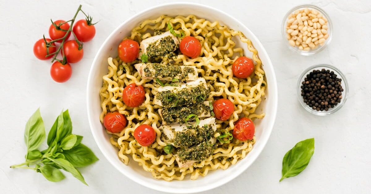 White bowl of pasta al pesto.
