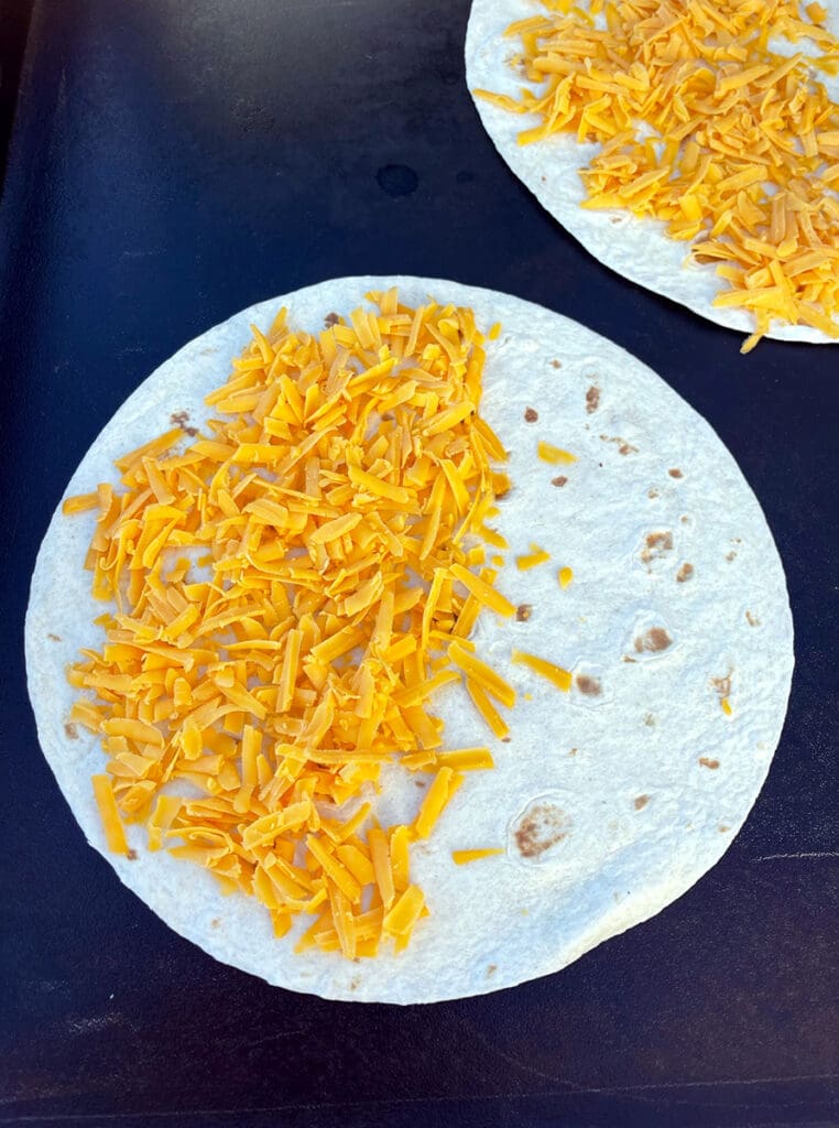 Tortilla with unmelted cheese on top.