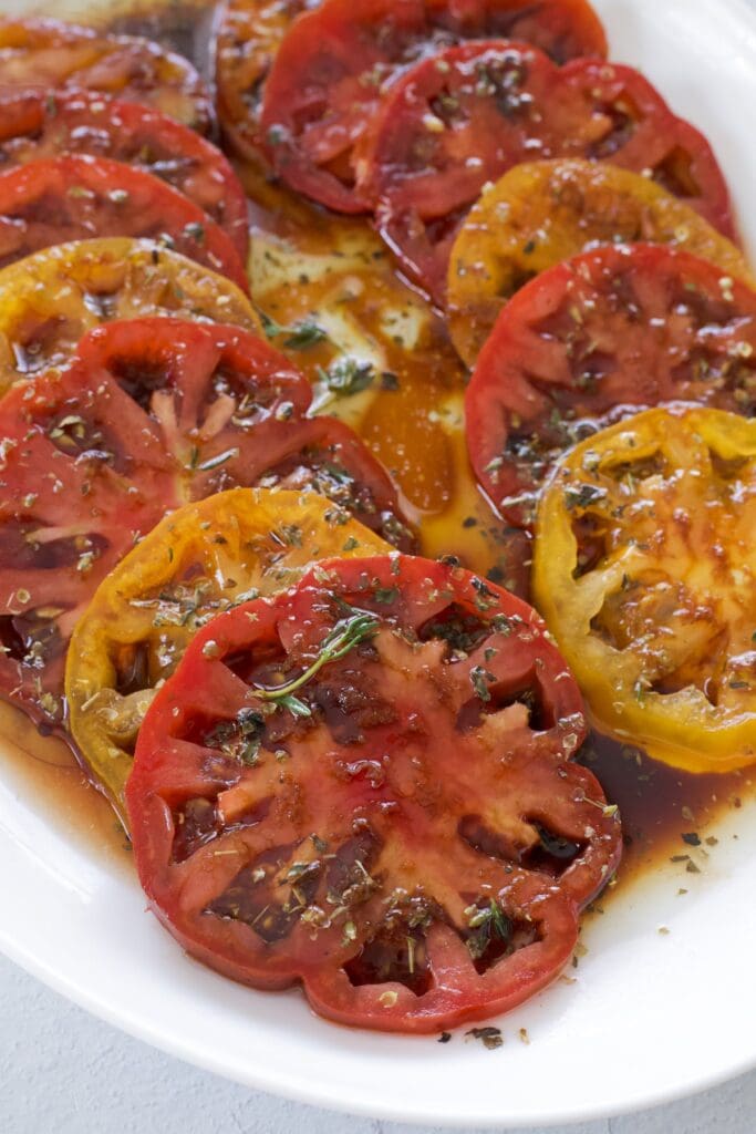 Plate full of sliced marinated tomatoes.